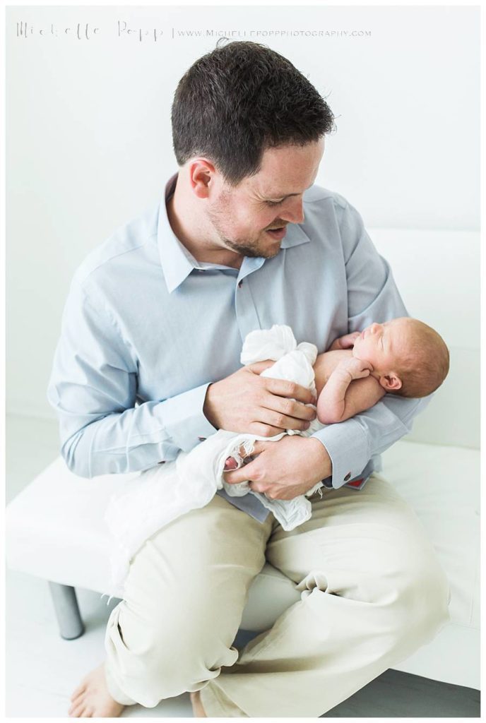 dad in blue shirt holding baby girl