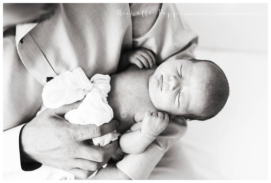 black and white of new baby in dads arms