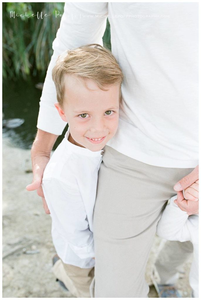 toddler boy hugging dads leg