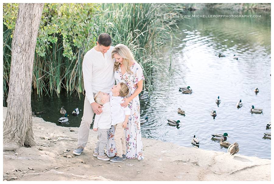 family of four by the lake with ducks