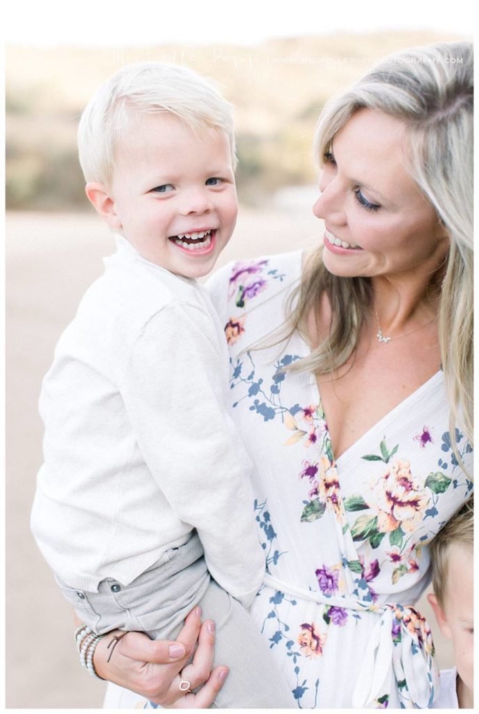 mom holding toddler boy smiling