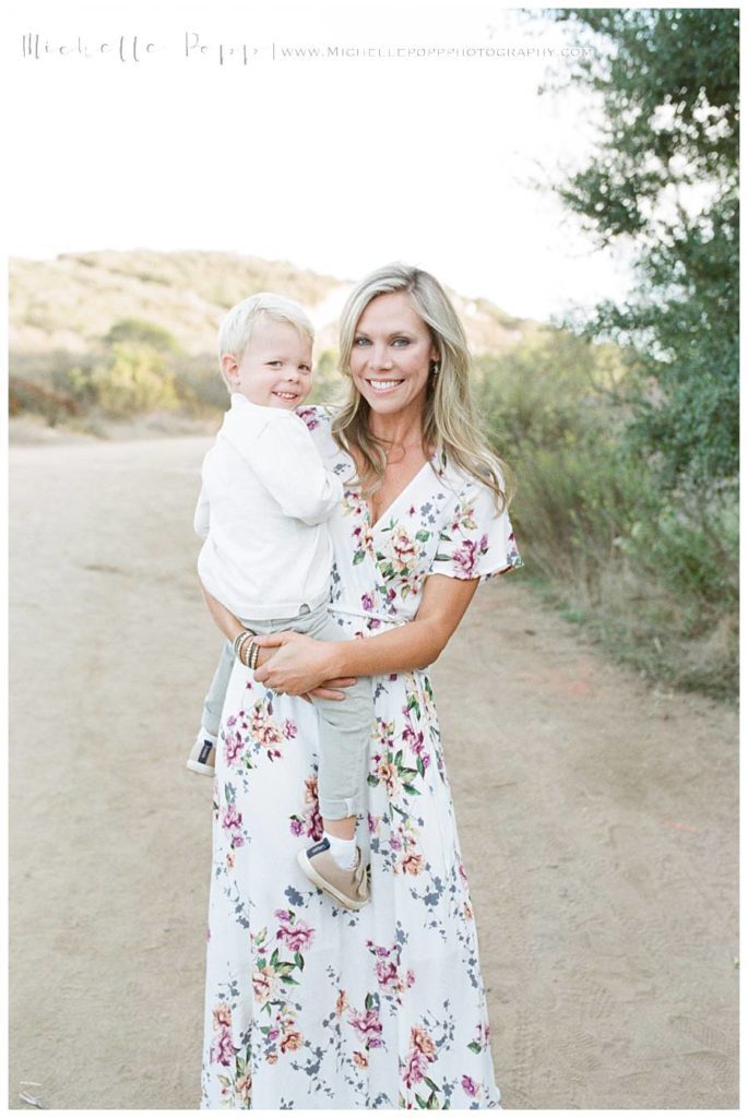 mom holding toddler boy smiling