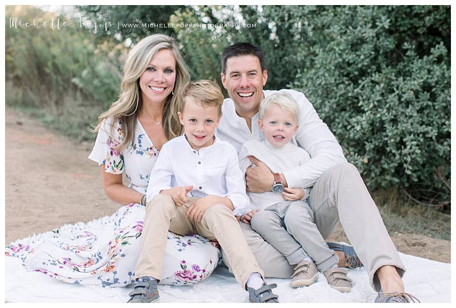 family of four in a field on a blanket