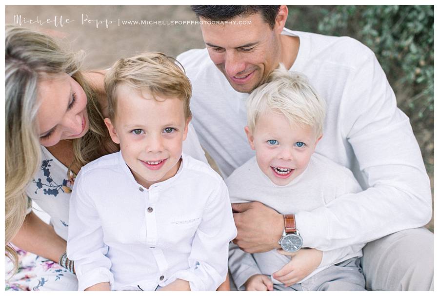 toddler boys smiling at camera in parents lap