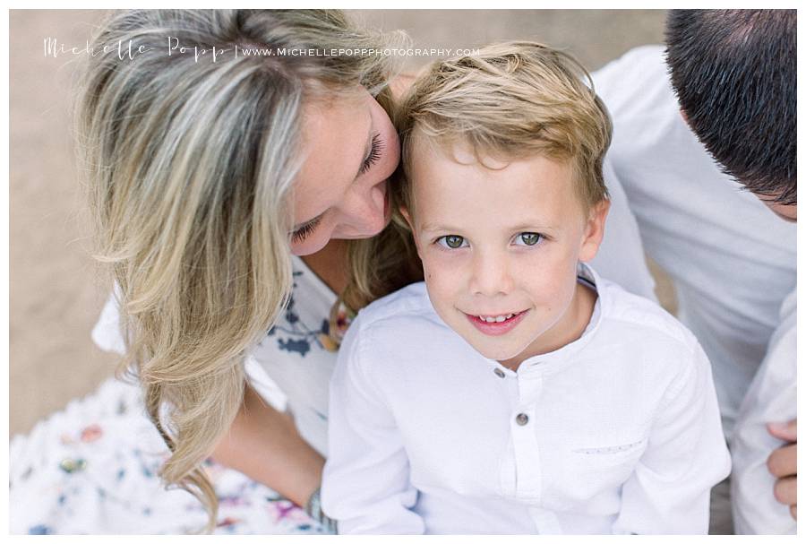 mom looking down at son as he smiling at camera