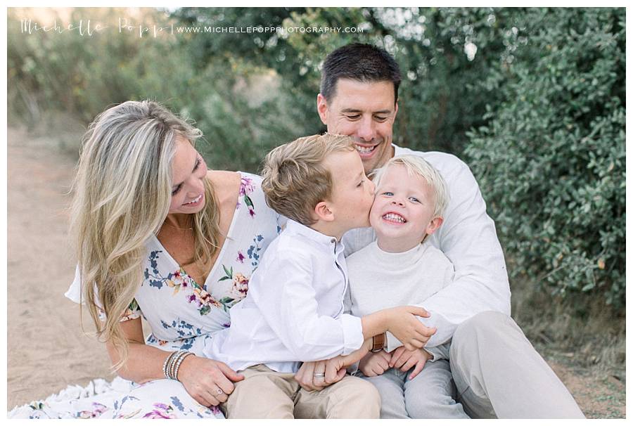 mom and dad holding toddler boys on lap