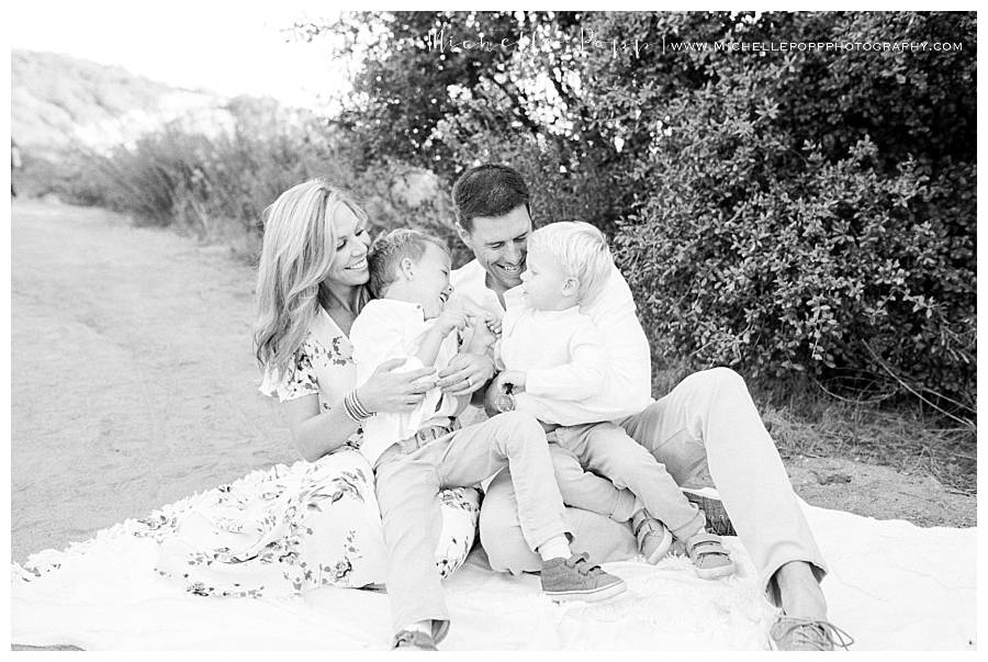 black and white of family of four on blanket