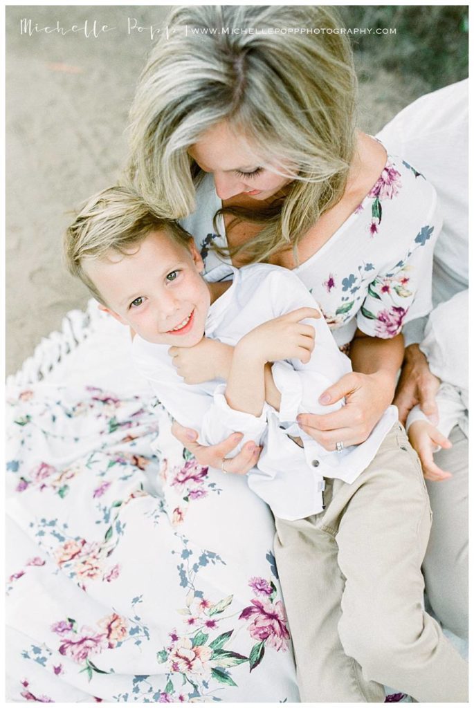 mom holding son on lap on blanket