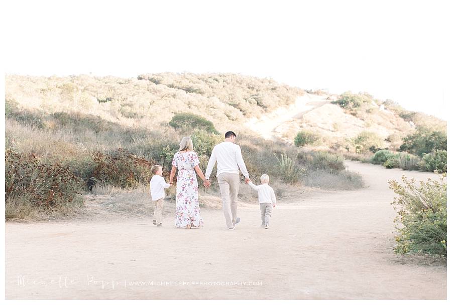 family of four walking holding hands