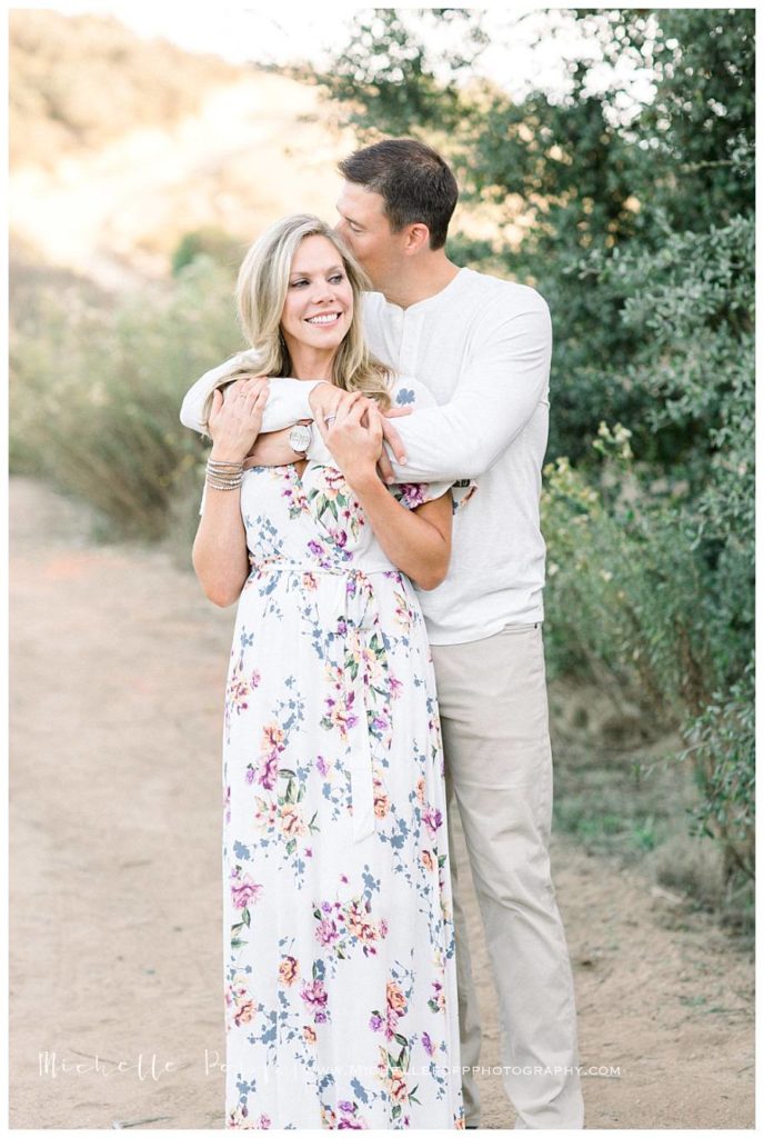 man holding woman from behind smiling