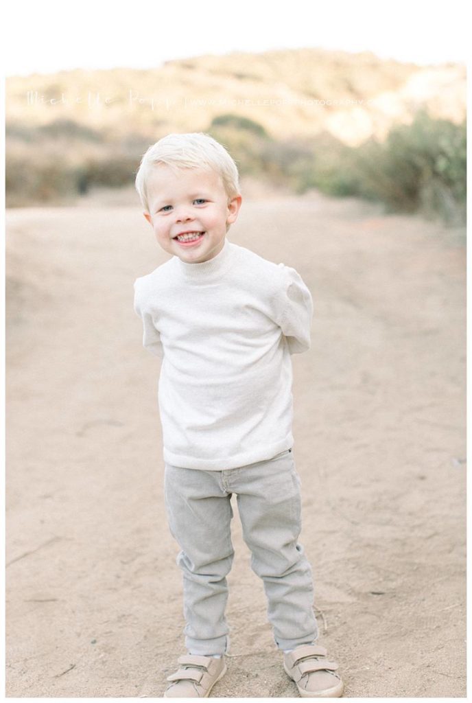 young boy in white shirt smiling at camera