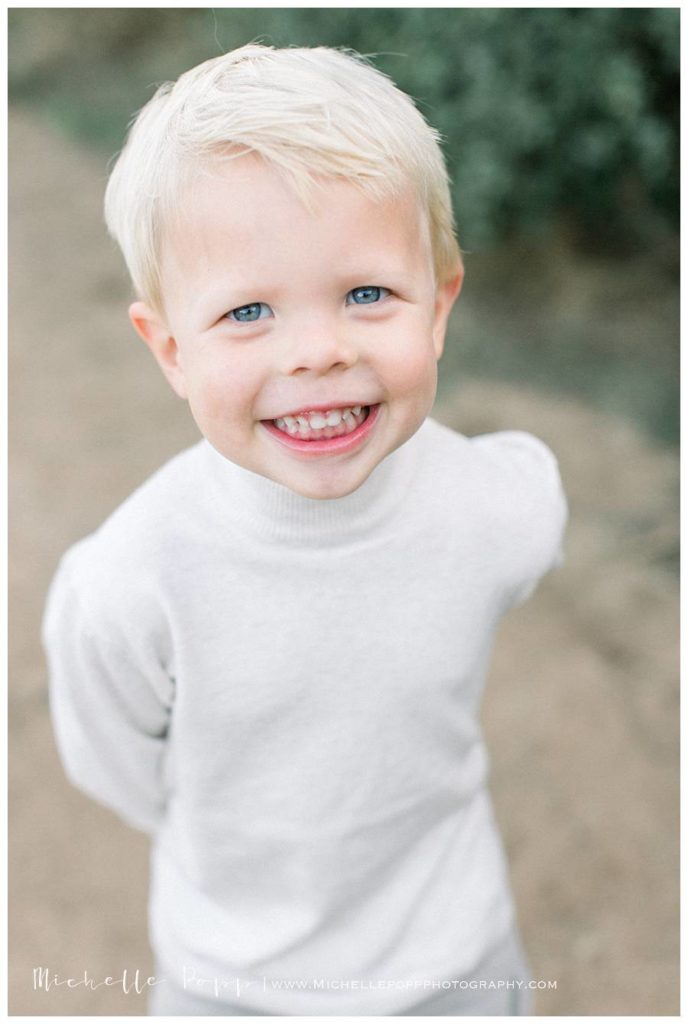 toddler boy in white shirt smiling at camera