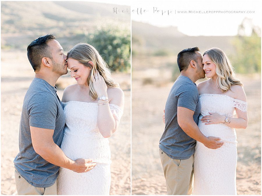 dad kissing mom to be on forehead in maternity photo