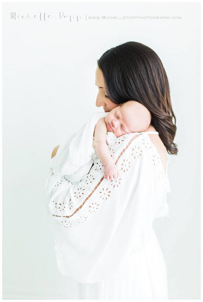 mom holding new baby on shoulder