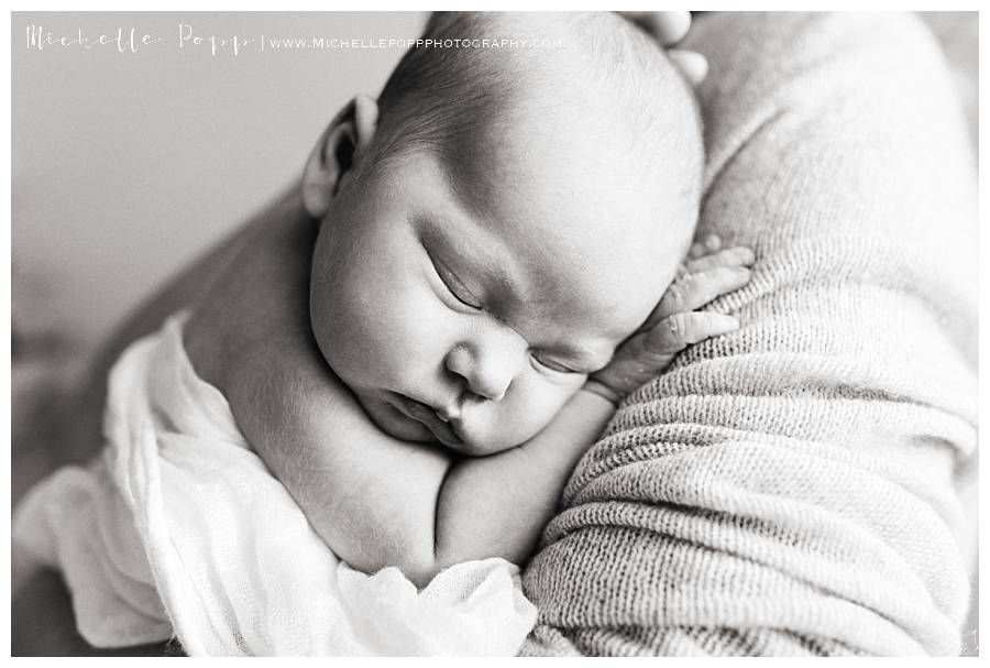 black and white of newborn sleeping on dad's chest