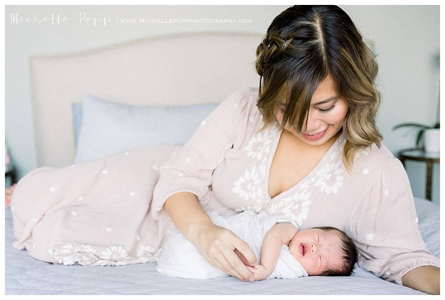 mom lying on bed with newborn baby girl