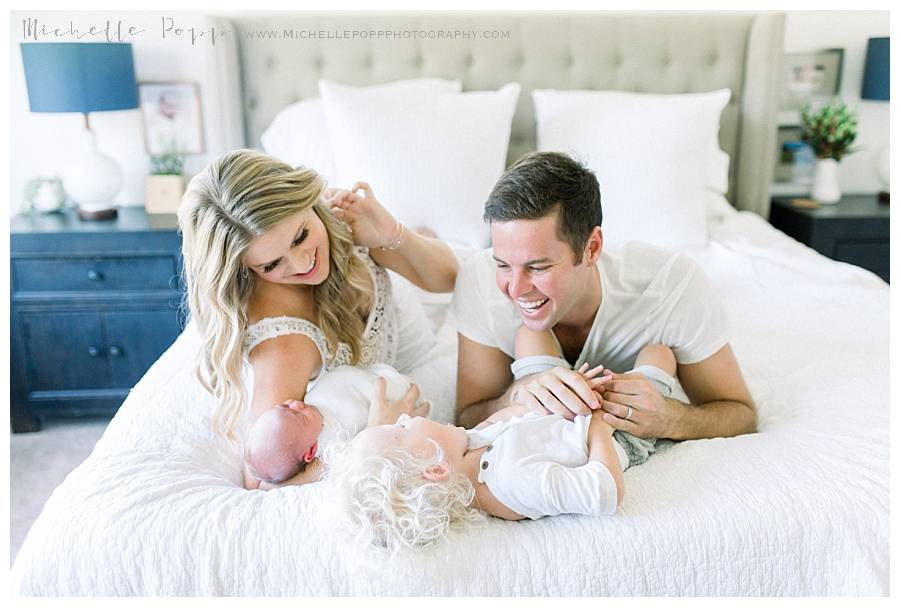 parents on bed with two kids laughing