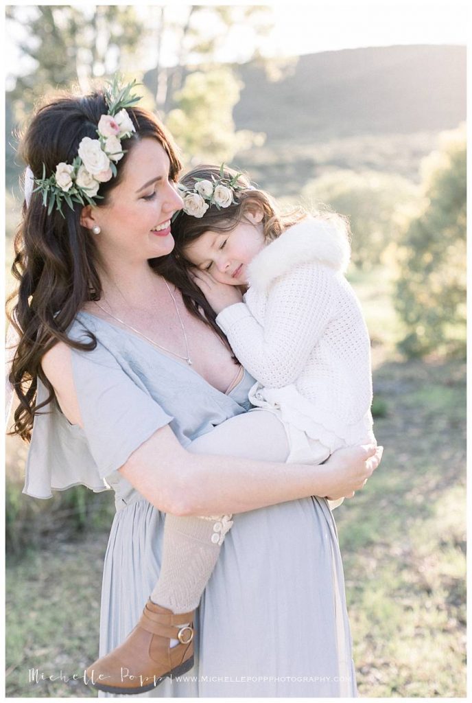 mom laughing holding daughter