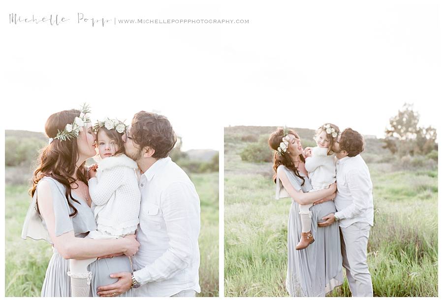 family of three in field hugging