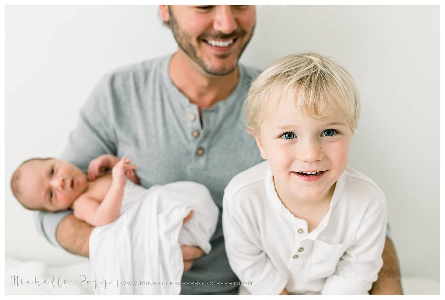 dad with son and new baby