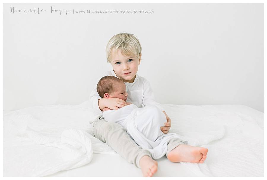 boy siblings sitting on bed