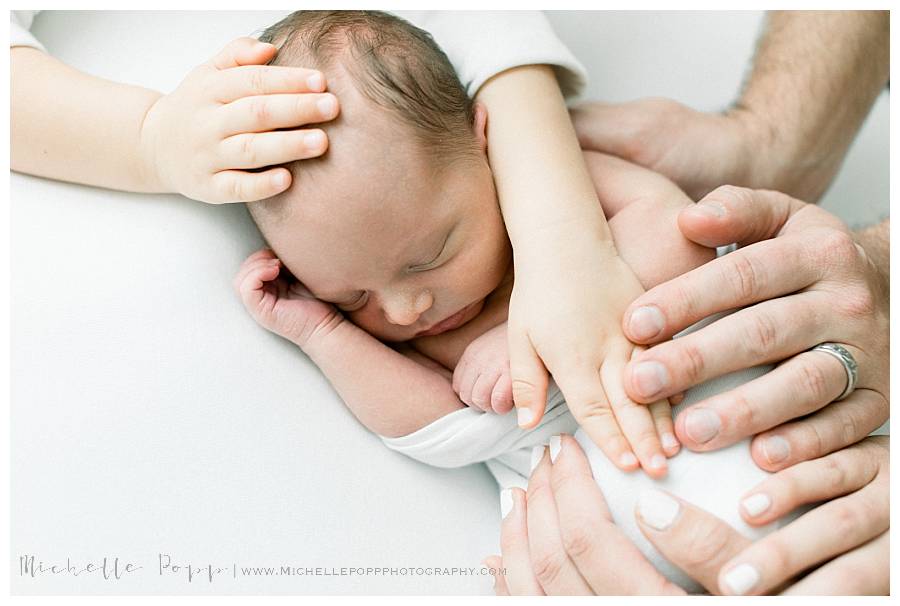 family hands on baby