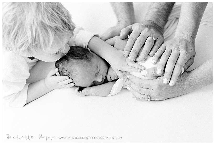 black and white family hands on baby