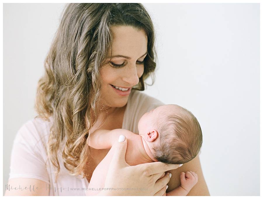 mom smiling down at newborn baby