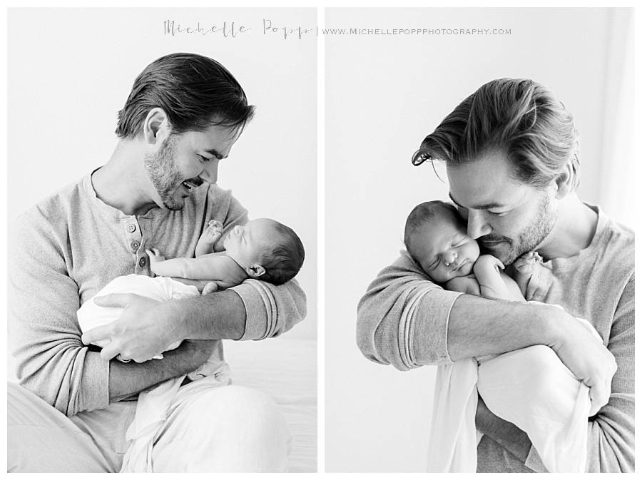 dad holding new baby black and white