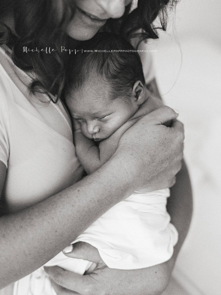 mom snuggling baby in b&w