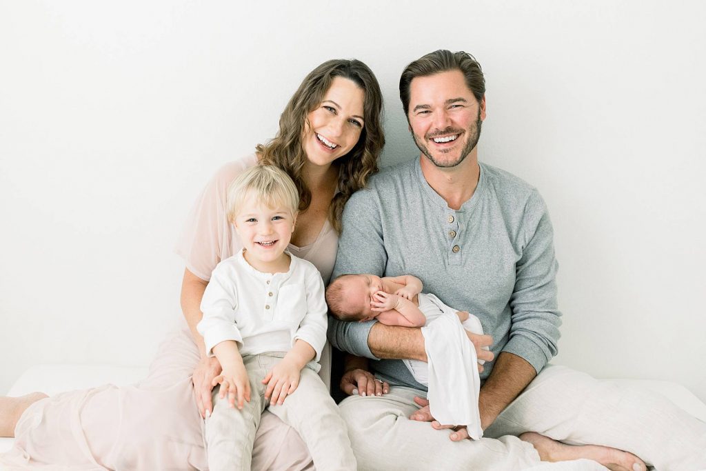 mom and dad on bed with newbown and son