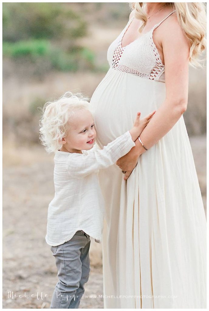 toddler hugging moms belly