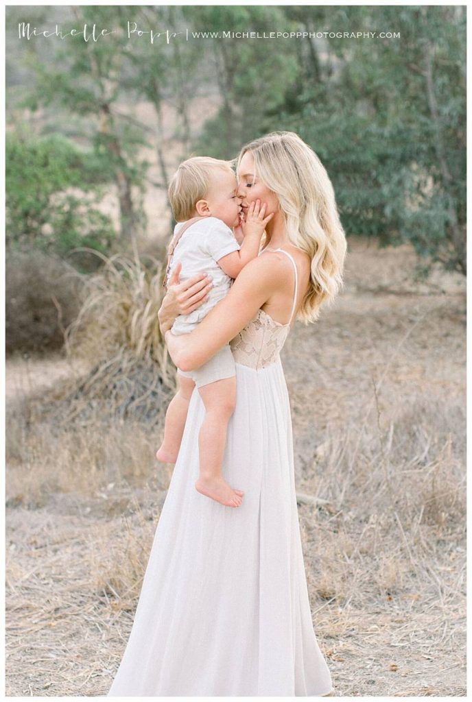 mom holding son and kissing his nose