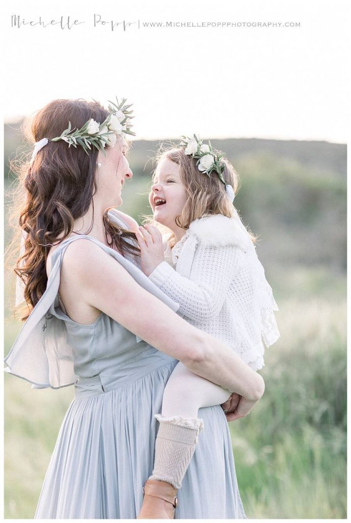 mom holding daughter and laughing