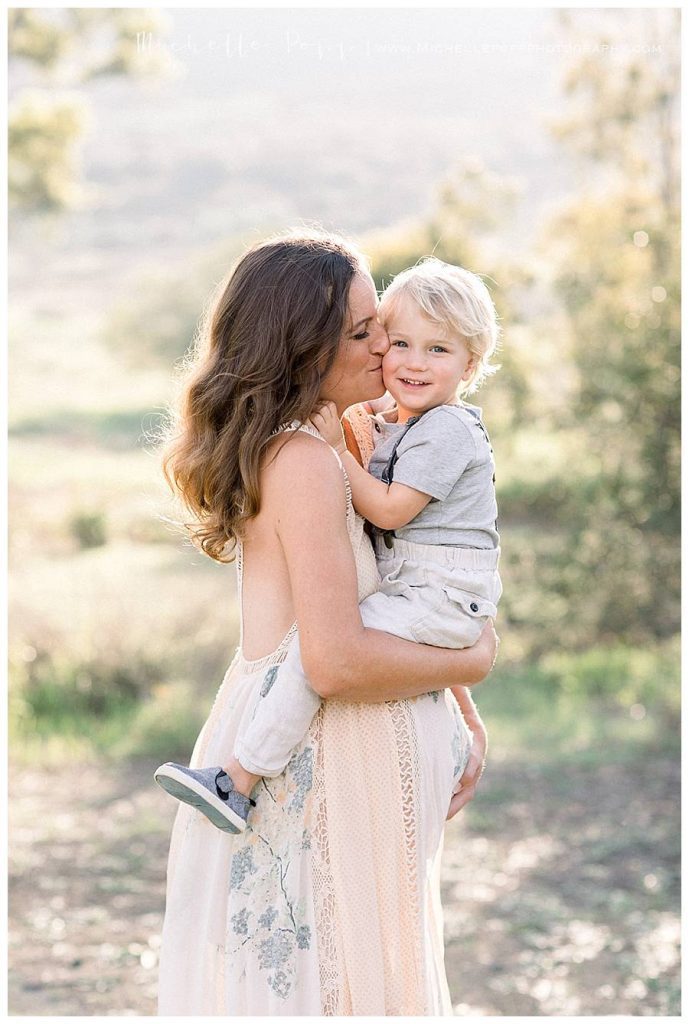 mom kissing son on cheek