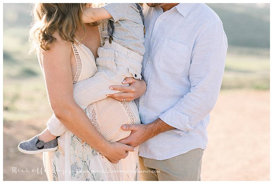 dad holding mom's belly