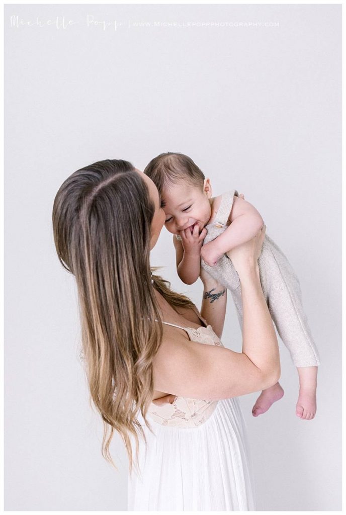 mom kissing 6 month old son