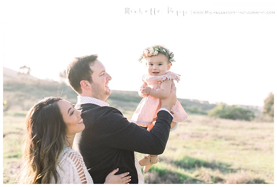 dad throwing baby girl up in the air