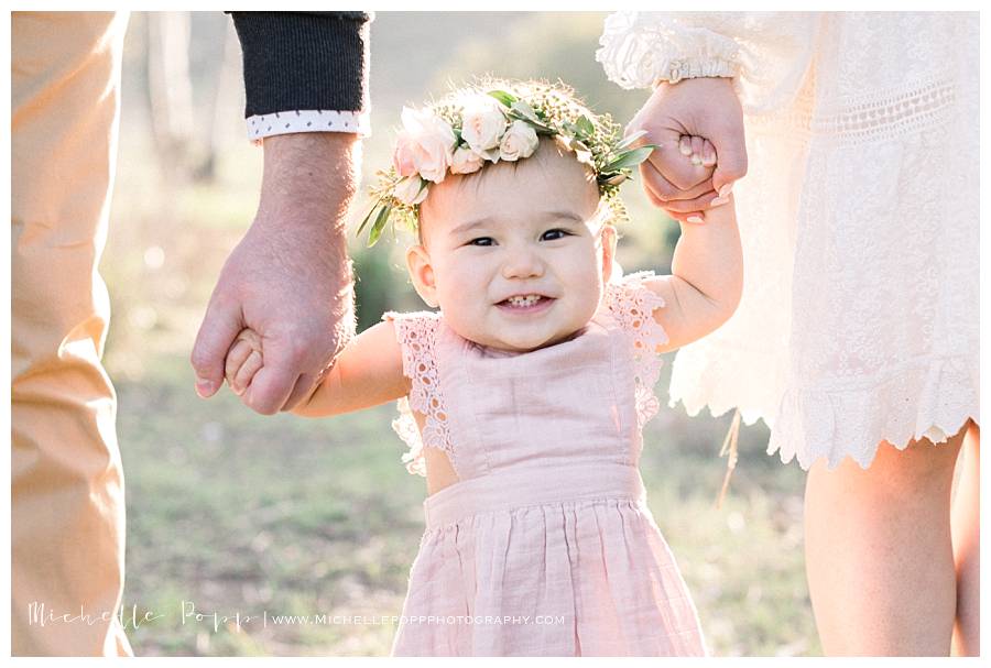 baby girl smiling at camera with floral crown