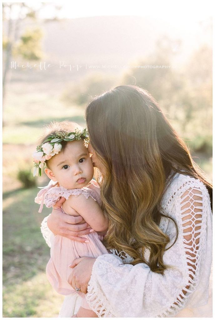 mom kissing baby girl