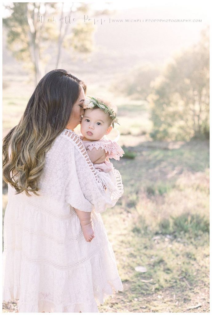 mom kissing daughter on cheek