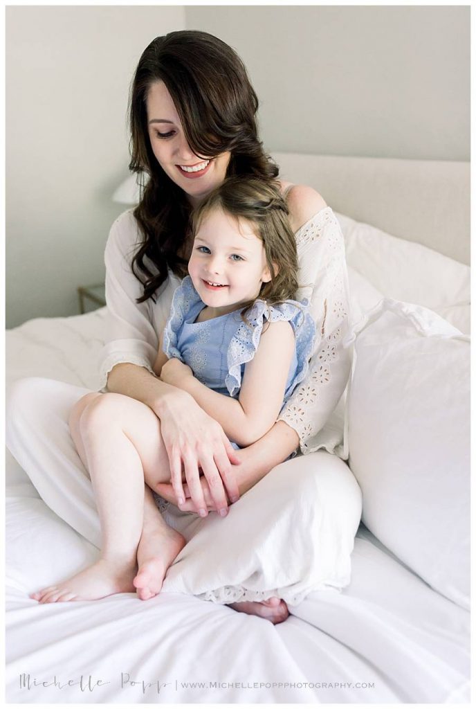 mom and daughter hugging on bed