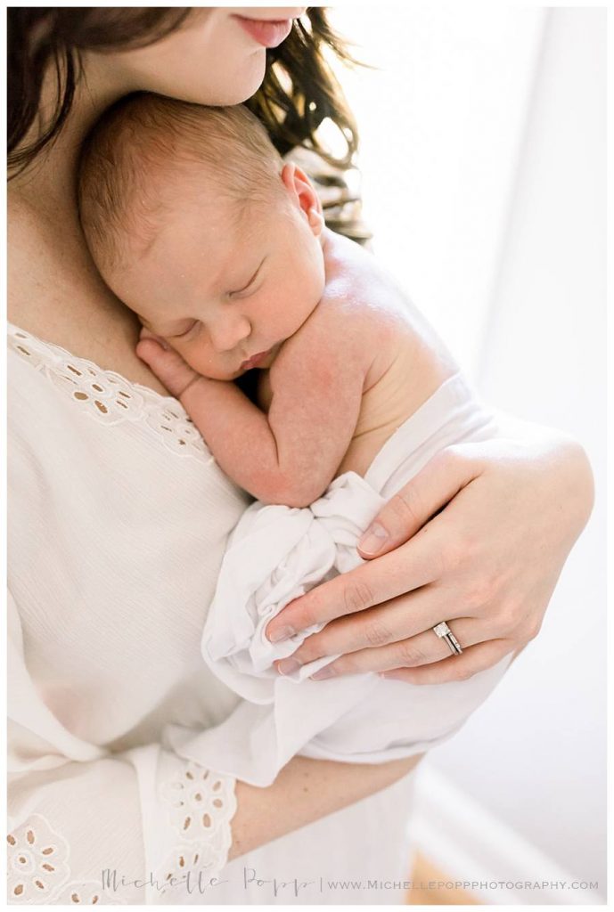 newborn baby snuggled on moms chest