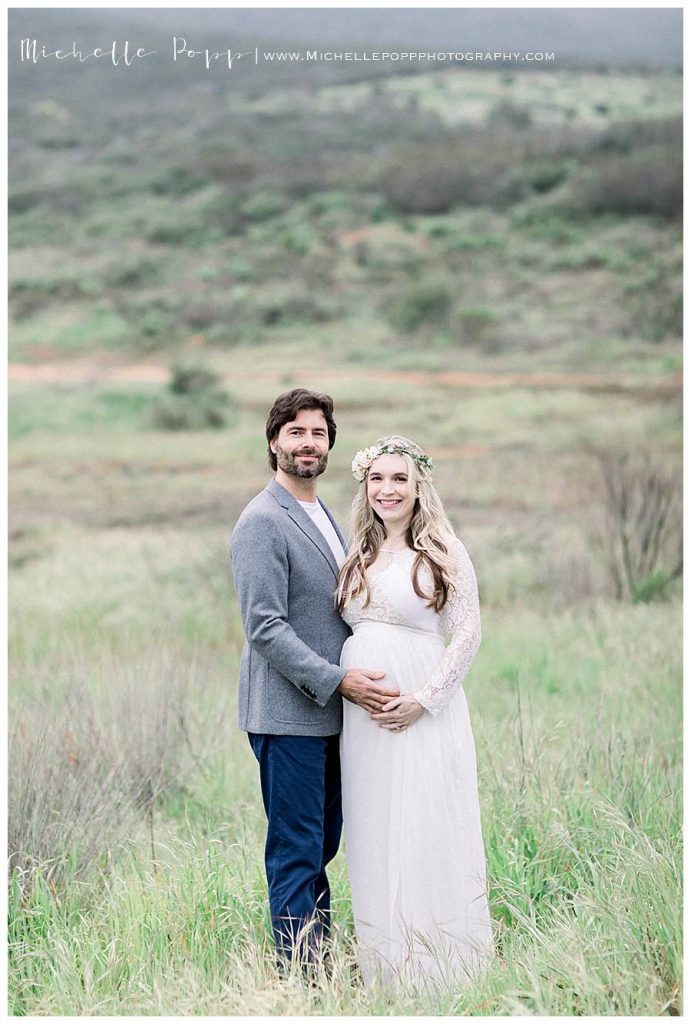 expectant mom and dad in a green field