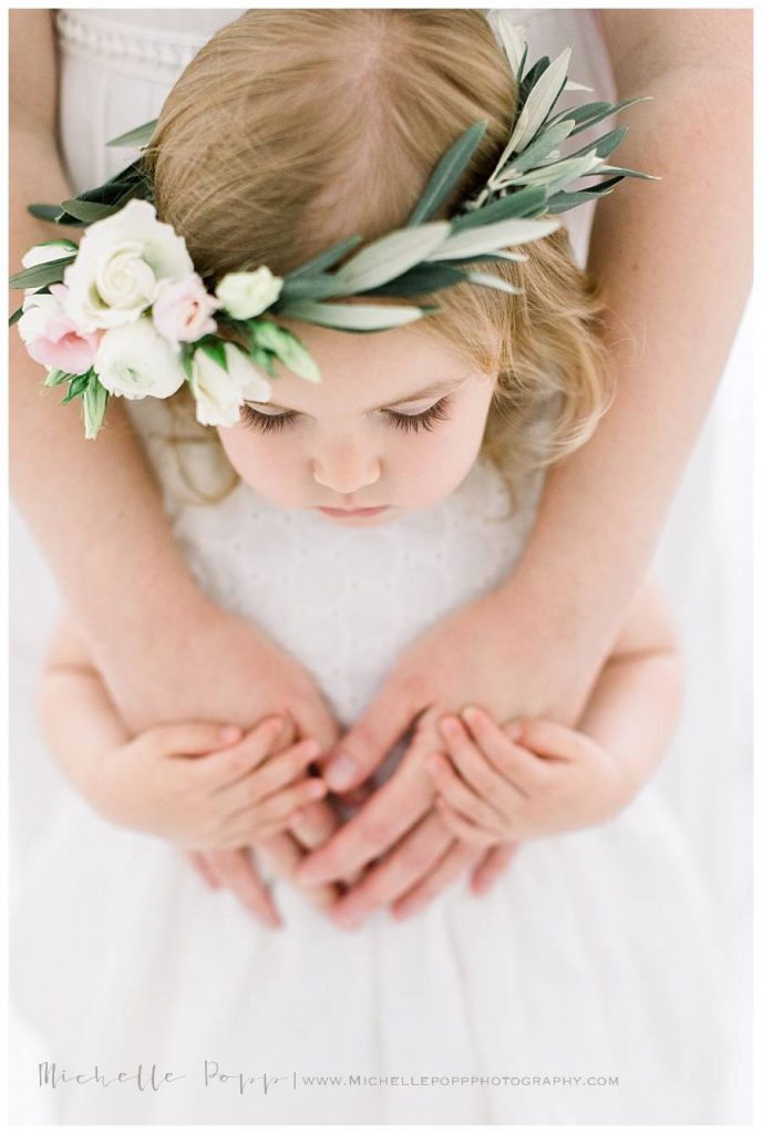 little girl in moms arms looking down