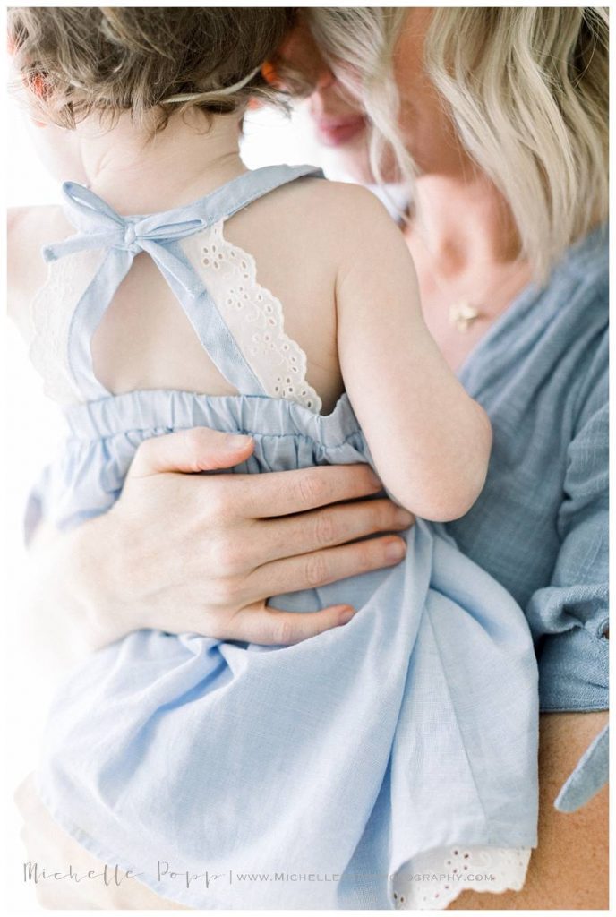 mother's hand on daughter's back