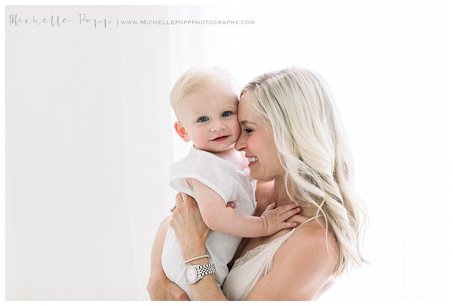 mom holding little boy and smiling