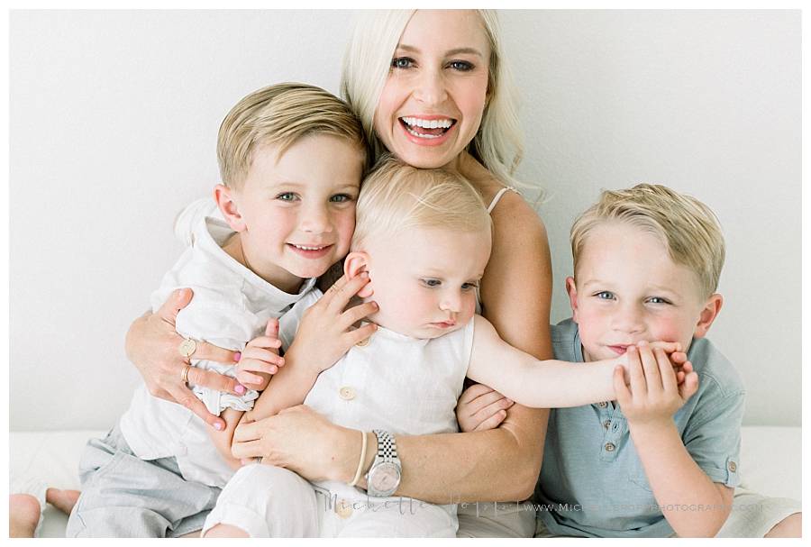 mom of three boys smiling and holding kids