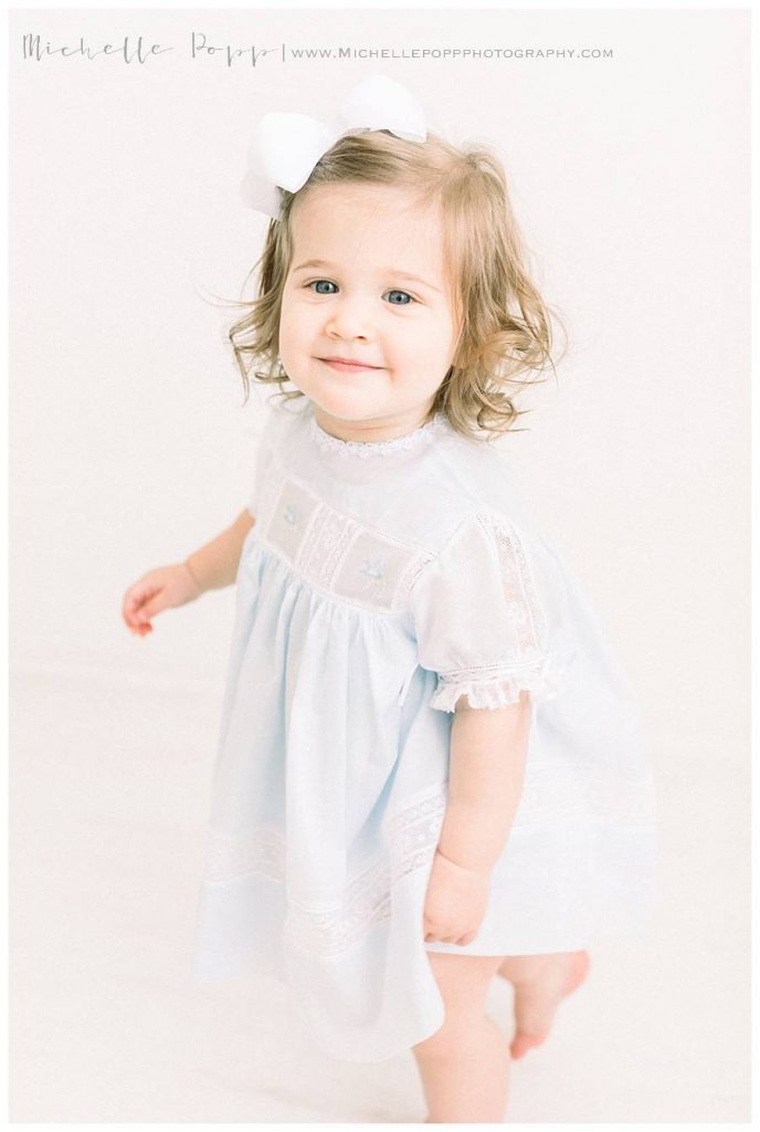 little girl in blue dress smiling