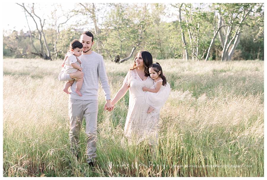 family of 4 walking in a field